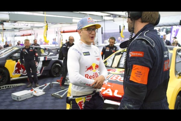 racing driver discussing car with pit team